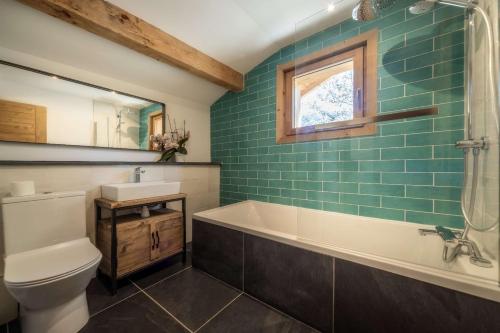 une salle de bain avec une baignoire, des toilettes et un lavabo dans l'établissement CHALET ROJI: superbe chalet moderne pour 10 personnes proche du centre, à Morzine