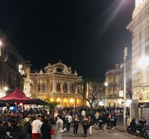 a crowd of people standing in front of a building at La casa al teatro in Catania