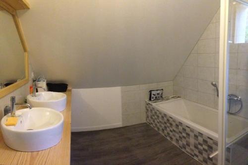 a bathroom with two sinks and a bath tub at Chalet spacieux Loudenvielle in Loudenvielle