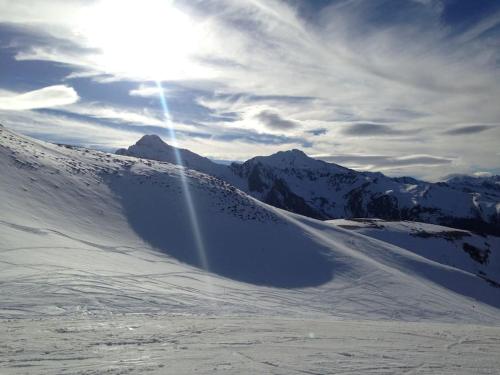 a snow covered mountain with the sun in the sky at Chalet spacieux Loudenvielle in Loudenvielle