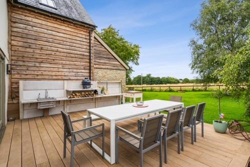 a patio with a table and chairs and a grill at Elmcroft, Large House with Shepherds Hut in Gillingham