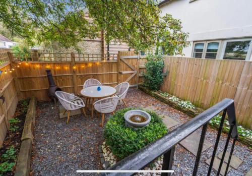 a patio with a table and chairs and a fence at Elmcroft, Large House with Shepherds Hut in Gillingham