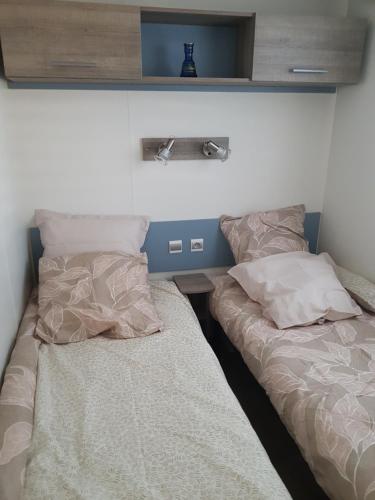 deux lits côte à côte dans une chambre dans l'établissement Mobilhome climatisé 6 pers, à Gujan-Mestras