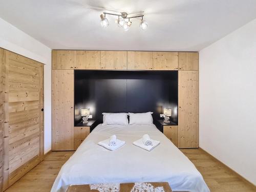 une chambre avec un grand lit avec deux serviettes dessus dans l'établissement Cardena- appartement- 8pers- proche centre, aux Gets