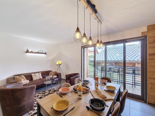 une salle à manger avec une table, des chaises et un canapé dans l'établissement Cardena- appartement- 8pers- proche centre, aux Gets