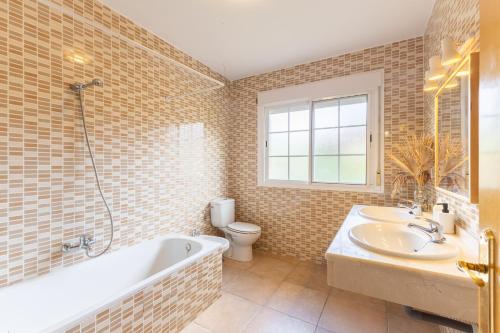a bathroom with a tub and a sink and a toilet at El Castillo in La Adrada