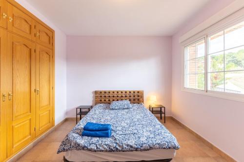 a bedroom with a bed with blue pillows on it at El Castillo in La Adrada