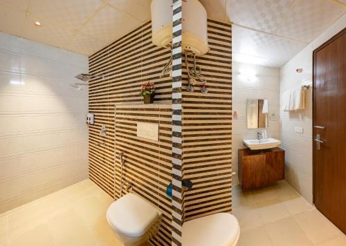 a bathroom with a toilet and a sink at Limewood Stay Oasis - Golf Course Road in Gurgaon