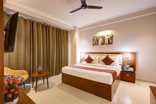 a hotel room with a bed and a television at Limewood Stay Oasis - Golf Course Road in Gurgaon
