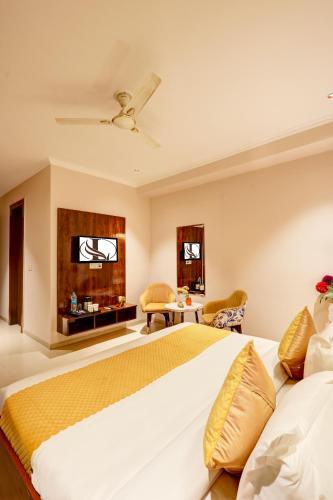 a bedroom with a large bed and a tv at Limewood Stay Oasis - Golf Course Road in Gurgaon