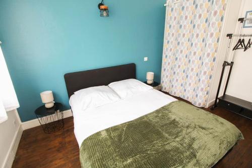une chambre avec un grand lit avec un mur bleu dans l'établissement NEW! St Martin 52B -Grand studio lumineux - wifi, à Angoulême