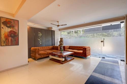 a living room with a couch and a table at Limewood Stay Oasis - Golf Course Road in Gurgaon