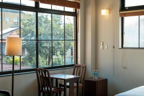a room with a table and two chairs and a window at Toyooka1925 in Toyooka