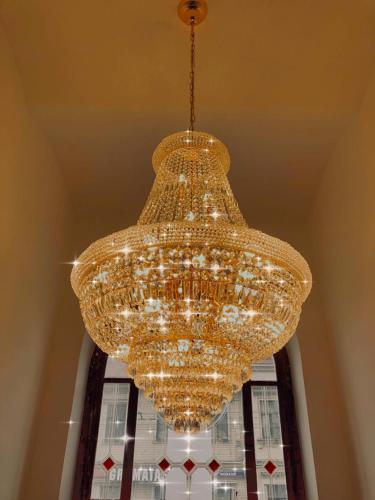 a large glass chandelier hanging from a ceiling at Aparthotel Amella in Rīga