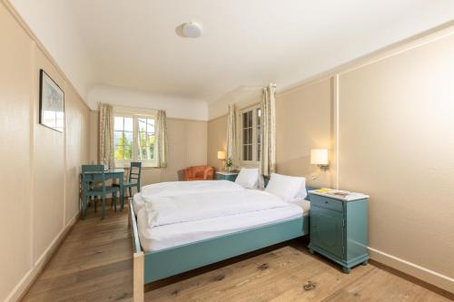 a bedroom with a bed and a table and chairs at Hotel Chesa Spuondas in St. Moritz