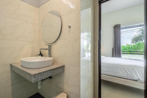 une salle de bain avec un lavabo et un miroir dans l'établissement De Gani, à Seminyak