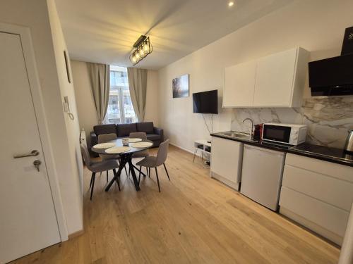 a kitchen and living room with a table and chairs at Modern apartment near Avenue Louise in Brussels