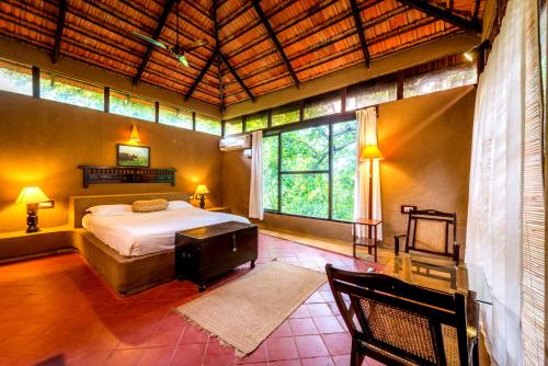 a bedroom with a bed and a large window at Mahua Vann Pench in Khawāsa