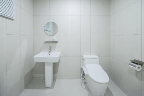 a white bathroom with a toilet and a sink at Aank Air Hotel Jinjuseong in Jinju