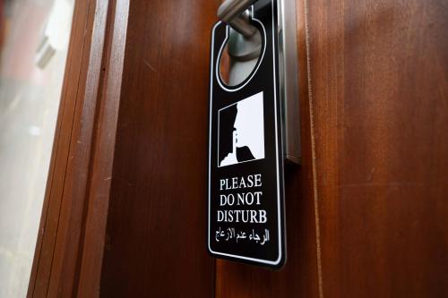 a sign on a door that says please dont disturb at فندق سيف بلص 2 من اورفانا in Makkah