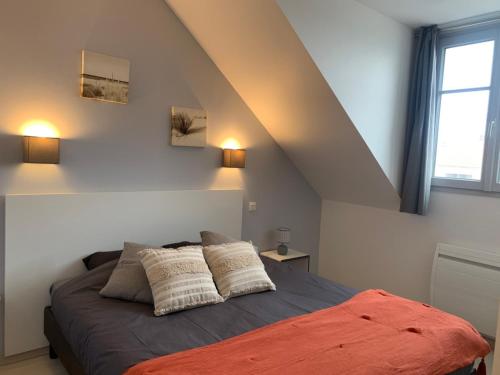 a bedroom with a bed with two pillows on it at Appartement 3ch - 2-5p - Parking et Piscine gratuit in Les Sables-dʼOlonne