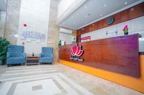 a lobby of a hospital with two blue chairs at فندق سيف بلص 2 من اورفانا in Makkah