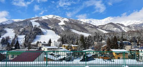 a town with snow covered mountains in the background at Summit Views Hakuba in Hakuba