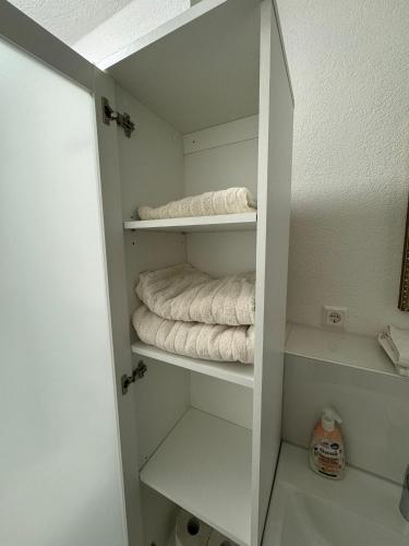 a white closet with white shelves and towels at Neues Apartment Ehingen 2.0 in Ehingen