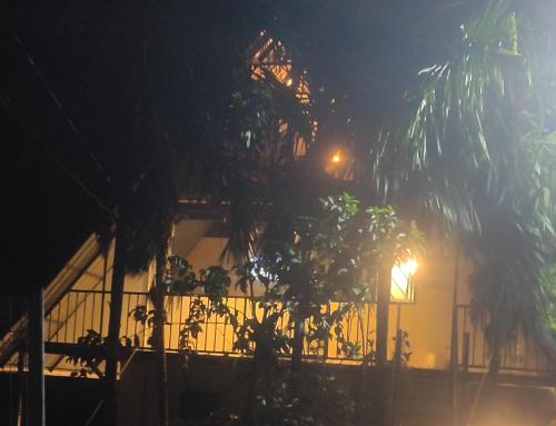 a house at night with a fence and a tree at Mount River Homestay in Palakkad
