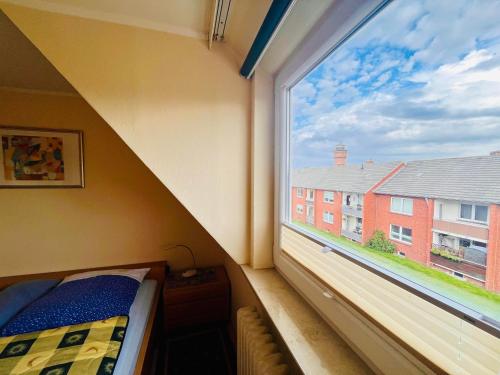 a bedroom with a large window and a bed at Ferienwohnung Janssen in Borkum