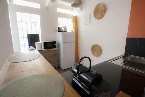 La cuisine est équipée d'une table, d'une cuisinière et d'un réfrigérateur. dans l'établissement NEW! St Martin 52C- Grand studio, à Angoulême