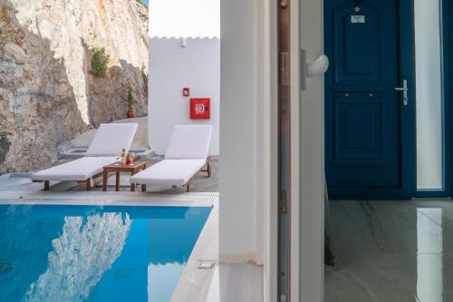 a house with a blue door and a pool at Kontemare Seascape in Koumeika