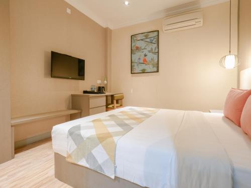 a bedroom with a bed and a tv on the wall at A Hotel Joo Chiat in Singapore