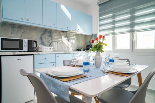 a white kitchen with a white table and chairs at Kontemare Seascape in Koumeika
