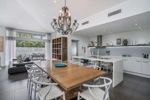 a kitchen and dining room with a table and chairs at Byron Marvel - Luxury Byron Bay Penthouse Holiday Rental with Balcony, 4 Bedrooms, Sleeps 10 in Byron Bay