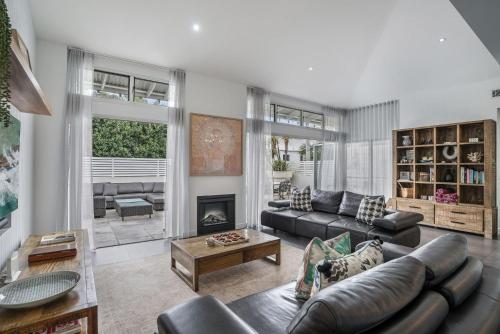 a living room with a couch and a fireplace at Byron Marvel - Luxury Byron Bay Penthouse Holiday Rental with Balcony, 4 Bedrooms, Sleeps 10 in Byron Bay