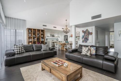 a living room with a couch and a table at Byron Marvel - Luxury Byron Bay Penthouse Holiday Rental with Balcony, 4 Bedrooms, Sleeps 10 in Byron Bay