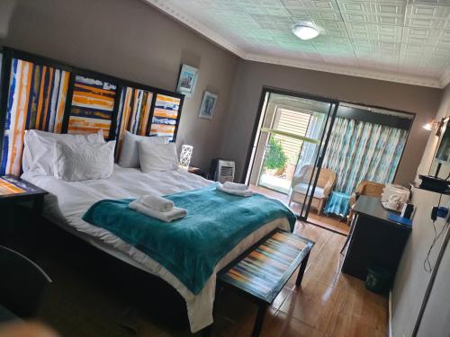 a bedroom with a large bed with towels on it at Blyde Lodge in Graskop