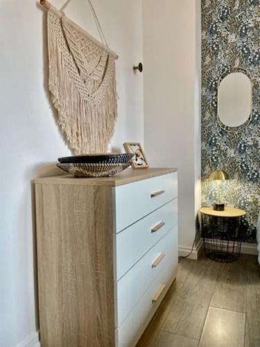 - une commode avec un panier dans l'établissement Appartement centre ville au calme, belles prestations, à Lorient