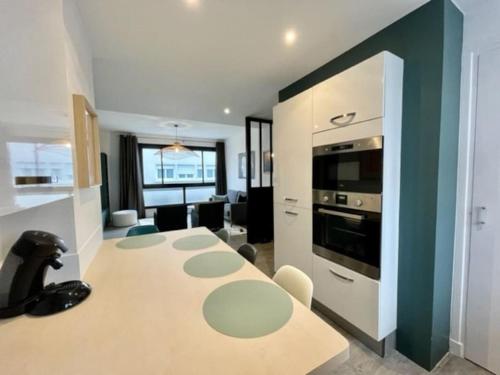 une cuisine avec une table et une cuisinière four supérieur dans l'établissement Appartement centre ville au calme, belles prestations, à Lorient
