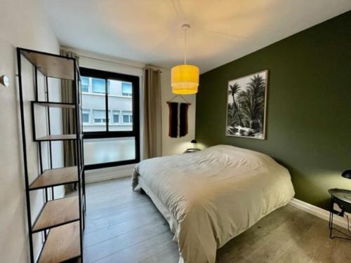 une chambre avec un lit et un mur végétal dans l'établissement Appartement centre ville au calme, belles prestations, à Lorient