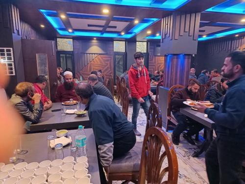 a group of people sitting at tables in a restaurant at Hotel Ruby and Restaurant in Srinagar