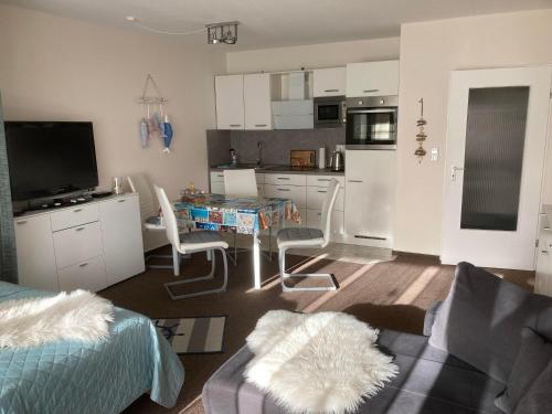 a living room with a couch and a table and a kitchen at Kiek mol wedder in in Borkum