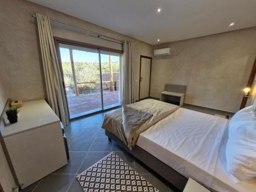 a bedroom with a bed and a large window at Le Parc des Oliviers in Marrakech