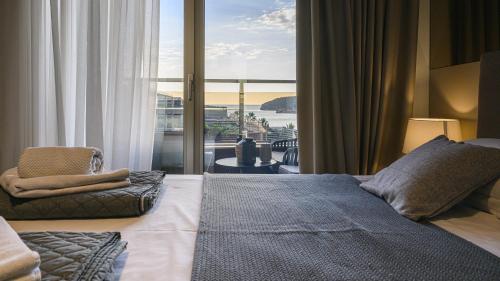 a bedroom with a bed and a view of the ocean at Budva Harmonia in Boreti
