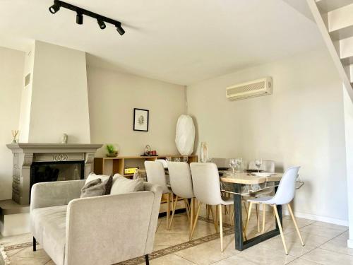 un salon avec un canapé, une table et des chaises dans l'établissement La Bovary, proche du CHU, à Isle