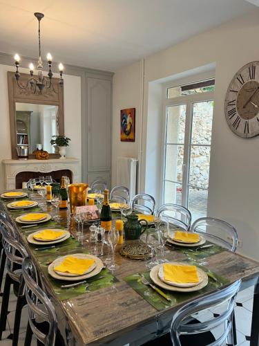 tavolo da pranzo con sedie e orologio sul muro di Le gîte de L'Echappée Champenoise a Sept-Saulx