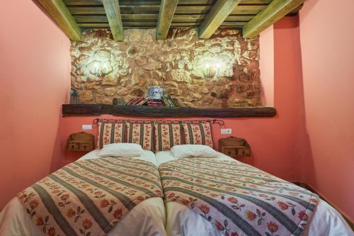 a bedroom with a bed in front of a stone wall at El Apartamento in Robledo de la Guzpeña