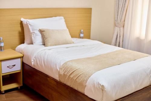 Una cama o camas en una habitación de Stunning & Calm 2 bedroom gate away in Entebbe- Sand Grains Residences A03