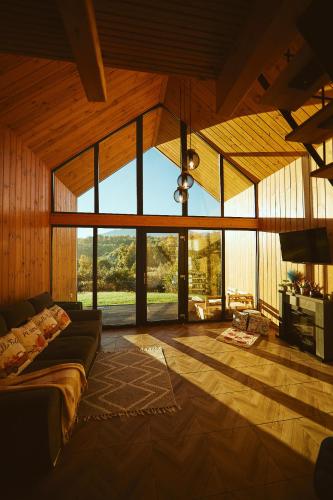 a large living room with a couch and large windows at Scandinave Chalet Bran in Zărneşti